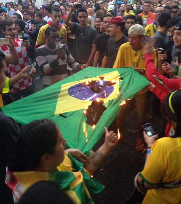Torcedores do Brasil queimando bandeira do país após derrota na semifinal da Copa do Mundo 2014 contra a Alemanha